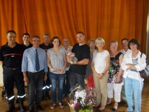 Léo Daoux, dans les bras de son papa, à la salle des fêtes de St-Marcel, en présence de sa maman des élus et des sapeurs pompiers.